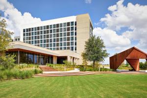 un bâtiment avec une pelouse devant lui dans l'établissement AC Hotel by Marriott Dallas Frisco, à Frisco