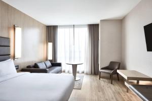 une chambre d'hôtel avec un lit et deux chaises dans l'établissement AC Hotel by Marriott Dallas Frisco, à Frisco