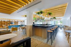 um restaurante com um bar e mesas e cadeiras em Courtyard by Marriott Cancun Airport em Cancún