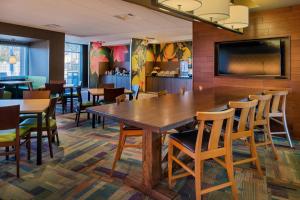 a dining room with a large wooden table and chairs at Fairfield Inn & Suites by Marriott Akron Stow in Stow