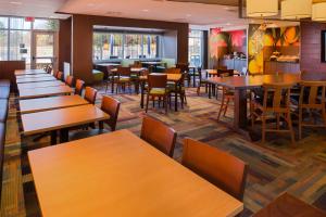 a restaurant with wooden tables and chairs and a cafeteria at Fairfield Inn & Suites by Marriott Akron Stow in Stow