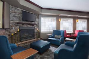 a waiting room with blue chairs and a fireplace at TownePlace Suites Pocatello in Pocatello