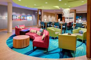 a lobby with chairs and tables and a bar at SpringHill Suites by Marriott Augusta in Augusta
