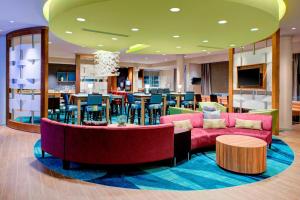 a lobby with couches and a table and a bar at SpringHill Suites by Marriott Augusta in Augusta