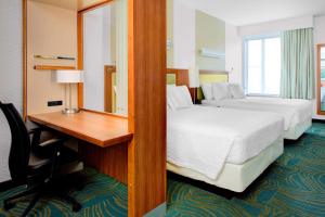 a hotel room with two beds and a desk and a mirror at SpringHill Suites by Marriott Augusta in Augusta