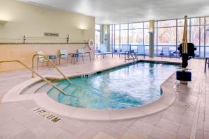 uma piscina num ginásio com cadeiras e mesas em SpringHill Suites by Marriott Augusta em Augusta