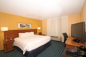 a hotel room with a bed and a flat screen tv at Fairfield Inn & Suites by Marriott Aiken in Aiken