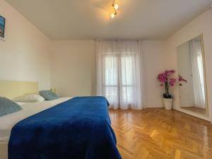 Un dormitorio con una cama con una manta azul. en Apartments Marija Magdalena, en Hvar