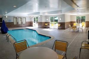 a pool in a room with tables and chairs at Fairfield Inn & Suites by Marriott Aiken in Aiken