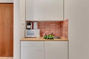 uma cozinha com armários brancos e um lavatório em CityFlow by Welcome Apartment em Gdańsk