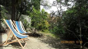 2 sillas de jardín sentadas en un patio con árboles en NICE - STUDIO indépendant en VILLA - Mer ville calme jardinet en Niza