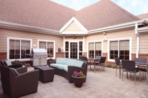 een patio met een bank, stoelen en een fornuis bij Residence Inn by Marriott Buffalo Galleria Mall in Cheektowaga