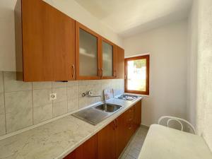 kuchnia z drewnianymi szafkami i zlewem w obiekcie Apartments Marija Magdalena w Hvarze