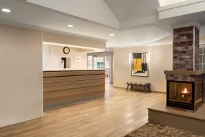 a living room with a fireplace and a counter at Residence Inn by Marriott Buffalo Galleria Mall in Cheektowaga