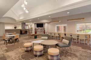 uma grande sala com mesas e cadeiras e uma cozinha em Residence Inn by Marriott Buffalo Galleria Mall em Cheektowaga