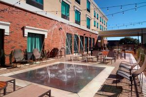 a fountain in a patio with tables and chairs at Courtyard by Marriott LaGrange in La Grange