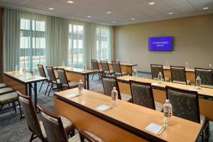 a conference room with tables and chairs and a tv at Courtyard by Marriott LaGrange in La Grange
