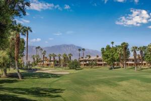 uitzicht op een golfbaan met palmbomen en huizen bij Marriott's Desert Springs Villas I in Palm Desert