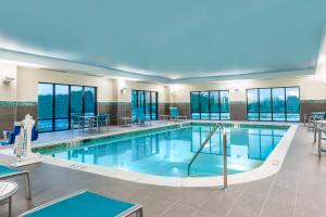 a large pool with tables and chairs in a building at TownePlace Suites by Marriott Latham Albany Airport in Latham