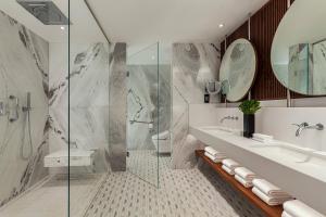 a bathroom with a sink and a shower at Malta Marriott Resort & Spa in St. Julianʼs