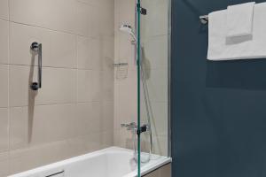 a bathroom with a shower and a bath tub at Bristol Marriott Royal Hotel in Bristol