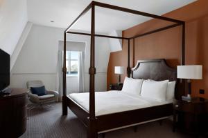 a bedroom with a canopy bed and a chair at Bristol Marriott Royal Hotel in Bristol