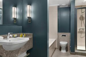 a bathroom with blue walls and a sink and a toilet at Bristol Marriott Royal Hotel in Bristol