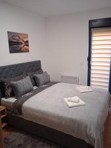 sypialnia z dużym łóżkiem z dwoma ręcznikami w obiekcie Apartman Andrijana w mieście Vrnjačka Banja