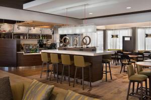 a kitchen with a bar and some tables and chairs at Courtyard by Marriott Boston Norwood/Canton in Norwood