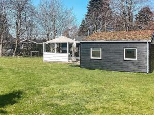 mały domek na podwórku z trawnikiem w obiekcie 6 person holiday home in V ggerl se w mieście Bøtø By