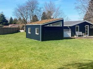 mały niebieski dom na polu trawy w obiekcie 6 person holiday home in V ggerl se w mieście Bøtø By