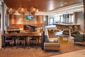 a restaurant with a bar and tables and chairs at SpringHill Suites by Marriott The Dunes On Monterey Bay in Marina