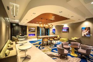 un hall avec des chaises et des tables ainsi qu'une salle à manger dans l'établissement SpringHill Suites by Marriott The Dunes On Monterey Bay, à Marina