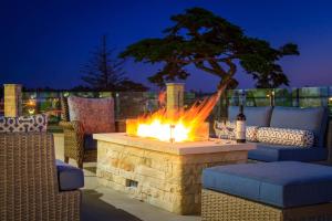 un foyer extérieur avec une table, des chaises et un arbre dans l'établissement SpringHill Suites by Marriott The Dunes On Monterey Bay, à Marina
