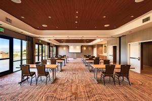 une salle de conférence avec des tables et des chaises et un écran de projection dans l'établissement SpringHill Suites by Marriott The Dunes On Monterey Bay, à Marina