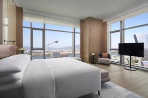 a bedroom with a large white bed and large windows at Fuzhou Marriott Hotel Riverside in Fuzhou