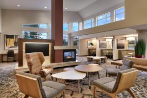 a lobby with a fireplace and tables and chairs at Residence Inn by Marriott Greenville in Greenville