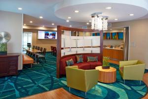 a lobby with a red couch and chairs and a table at SpringHill Suites by Marriott Atlanta Six Flags in Lithia Springs