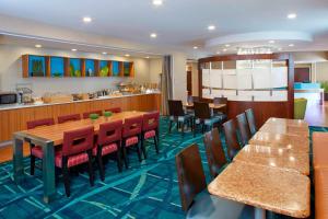 um restaurante com mesas e cadeiras e uma cozinha em SpringHill Suites by Marriott Atlanta Six Flags em Lithia Springs