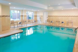 uma piscina num quarto de hotel com cadeiras e mesas em SpringHill Suites by Marriott Atlanta Six Flags em Lithia Springs