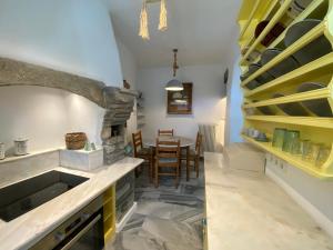 a kitchen with a table and a stone fireplace at Villa Meltemi in Arnados +5 photos