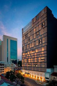 a tall building with lights on in a city at Hotel Stripes Kuala Lumpur, Autograph Collection in Kuala Lumpur