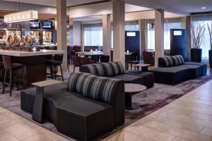 a lobby with couches and tables and a bar at Courtyard Des Moines West/Clive in Clive