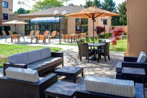 a patio with couches and tables and chairs at Courtyard Des Moines West/Clive in Clive