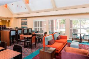 a hotel lobby with tables and chairs and a bar at Residence Inn Corpus Christi in Corpus Christi