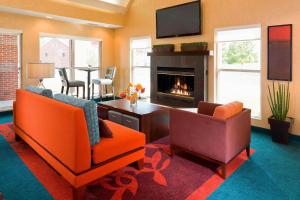 a living room with two chairs and a fireplace at Residence Inn Appleton in Appleton