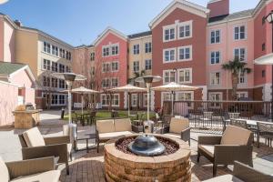 a courtyard with chairs and a fountain in front of buildings at Residence Inn by Marriott Charleston Airport in Charleston