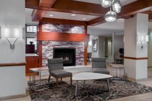 a lobby with a fireplace and chairs and tables at Residence Inn by Marriott Charleston Airport in Charleston