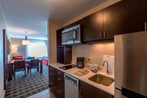a kitchen with a sink and a living room at TownePlace Suites by Marriott Hopkinsville in Hopkinsville