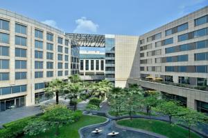 arial view of a building with palm trees and buildings at JW Marriott Hotel New Delhi Aerocity in New Delhi